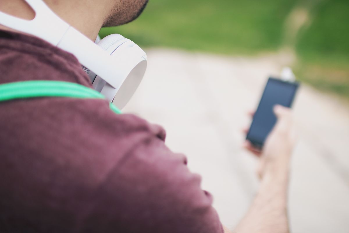 Hombre con auriculares Bluetooth y smartphone